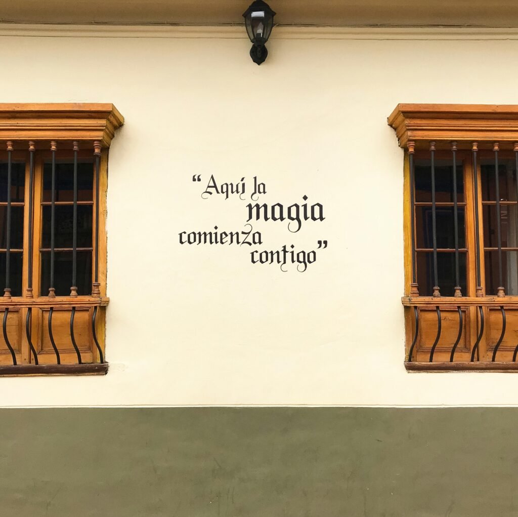 pexels-photo-1292468-1292468 Colorful house facade in Bogotá with an inspiring Spanish quote on the wall, perfect for travel themes.